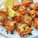 You need 1 pound of fresh salmon. Make sure it's skinless. Cut the salmon into small, bite-sized cubes. This helps them cook evenly in the air fryer. Fresh salmon gives the best taste and texture. Look for bright color and no strong smell when you shop. For the garlic butter sauce, use 4 tablespoons of unsalted butter. Melt the butter in a bowl. Add 3 cloves of minced garlic to the melted butter. The garlic gives a strong flavor. Then, mix in 1 tablespoon of finely chopped fresh parsley. This adds a nice touch of color and taste. Don't forget 1 teaspoon of lemon juice. It adds freshness to the sauce. Lastly, include ½ teaspoon of paprika, along with salt and pepper to taste. This mix creates a rich and tasty marinade. You can use lemon wedges when serving. They add a zesty flavor when squeezed over the salmon bites. The lemon brightens up the dish. It also helps cut through the richness of the garlic butter. If you want, you can sprinkle more chopped parsley on top for extra color. This makes the dish look even more appealing. Start by mixing the garlic butter marinade. In a medium bowl, add 4 tablespoons of melted butter. Next, add 3 minced garlic cloves. Then, toss in 1 tablespoon of fresh parsley, finely chopped. Squeeze in 1 teaspoon of lemon juice and sprinkle in ½ teaspoon of paprika. Finally, season with salt and pepper to taste. Stir everything well until it is blended nicely. Cut your fresh salmon into bite-sized cubes, about 1 inch each. Place the salmon cubes into your bowl with the garlic butter marinade. Gently toss the salmon until each piece is coated. Let the salmon marinate for 15 to 20 minutes. This step brings out the full flavor of the garlic butter. While the salmon marinates, preheat your air fryer to 375°F (190°C) for about 5 minutes. Lightly grease the air fryer basket. You can use cooking spray or a bit of oil to prevent sticking. Once ready, arrange the marinated salmon cubes in a single layer in the basket. Make sure they are not crowded, as air needs to flow around them. Cook the salmon bites for 7 to 10 minutes. Shake the basket halfway through for even cooking. The salmon is done when it turns golden and reaches an internal temperature of 145°F (63°C). Remove the salmon bites and serve them hot with lemon wedges for extra flavor. To get perfectly cooked salmon, focus on size. Cut your salmon into even cubes. This helps them cook at the same rate. Keep an eye on the cooking time. Check for a golden color and a soft texture. Use a meat thermometer to ensure an internal temperature of 145°F (63°C). You can boost the flavor of your salmon bites easily. Add a pinch of red pepper flakes for heat. A splash of soy sauce can add depth. Fresh herbs like dill or cilantro can brighten the dish. Don’t forget to try different citrus juices, like lime or orange, for a twist. One big mistake is overcrowding the air fryer basket. Give your salmon bites space for air to flow. This ensures they cook evenly. Also, don’t skip preheating your air fryer. It helps the salmon cook faster and more evenly. Lastly, remember to shake the basket halfway through cooking to avoid sticking and ensure an even crust. {{image_2}} You can switch up the flavors in your garlic butter marinade. Try using olive oil instead of butter for a lighter twist. Add soy sauce or honey for a sweet and savory mix. You can also use different herbs like dill or basil to change the taste. A splash of hot sauce can add a nice kick too. If you don’t have an air fryer, no worries! You can pan-sear the salmon bites in a skillet. Heat some oil over medium heat and cook for 3-4 minutes on each side. You can also bake them in the oven. Set the oven to 400°F (200°C) and cook for 12-15 minutes. Both methods give you a tasty dish. These salmon bites pair well with many sides. Try a fresh salad for a light meal. Roasted veggies or rice also make great options. For a fun twist, serve them in tacos with slaw and avocado. Don’t forget lemon wedges for a bright finish! To keep your air fryer garlic butter salmon bites fresh, store them right. First, let the salmon bites cool down to room temperature. Then, place them in an airtight container. This helps to keep moisture in and air out. You can store the salmon bites in the fridge for up to three days. Make sure to label the container with the date. This way, you won’t forget when you made them. If you want to save salmon bites for later, freezing is a great option. Place the cooled salmon bites in a freezer-safe bag or container. Try to remove as much air as possible to avoid freezer burn. You can freeze them for up to three months. When you’re ready to eat, just take them out and let them thaw in the fridge overnight. To enjoy your salmon bites again, reheating needs to be done right. You can use the air fryer for best results. Preheat the air fryer to 350°F (175°C). Place the salmon bites in the basket and heat for about 5 minutes. This will keep them crispy. You can also use a microwave, but it may make them a bit soggy. If you use the microwave, heat in short bursts to avoid overcooking. You should air fry salmon bites for 7 to 10 minutes. The exact time depends on the size of the cubes. Make sure to shake the basket halfway through. This helps them cook evenly. The salmon is ready when it turns golden and reaches an internal temp of 145°F (63°C). Yes, you can use frozen salmon for this recipe. Just make sure to thaw it first. You can do this by placing it in the fridge overnight. If you're short on time, place it in a sealed bag and submerge it in cold water. After thawing, cut it into bite-sized cubes and follow the recipe as usual. Several dipping sauces go well with garlic butter salmon bites. Here are some tasty options: - Lemon aioli: This creamy dip adds a nice zing. - Honey mustard sauce: It provides a sweet and tangy flavor. - Tartar sauce: A classic choice that complements seafood well. - Chili garlic sauce: For those who like a little heat. Feel free to experiment with different sauces to find your favorite! This guide covered how to make tasty garlic butter salmon bites. We explored the key ingredients, including fresh salmon and seasonings. I shared easy steps for marinating and cooking the salmon in an air fryer. You received helpful tips for perfecting your dish and learned about variations for added flavor. Lastly, I explained how to store leftovers properly. These bites are quick and fun to make. Enjoy your cooking adventure, and impress others with your skills.