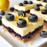 Let’s talk about the key ingredients you need for these blueberry lemon cheesecake bars. Each one plays an important role in making this dessert tasty and rich. - Graham cracker crumbs: You need 1 ½ cups to create a crunchy crust. - Unsalted butter: Half a cup, melted, helps bind the crumbs together. - Sugar: Two tablespoons sweeten the crust. One cup is used in the filling. - Cream cheese: Sixteen ounces of softened cream cheese gives the filling its rich texture. - Eggs: Three large eggs help set the cheesecake. - Vanilla extract: Two teaspoons add a warm flavor to the filling. - Lemon zest and juice: Zest from one lemon and a quarter cup of fresh lemon juice brighten the taste. - Fresh blueberries: One cup, plus extra for garnish, infuses the bars with fruity goodness. - Cornstarch: One tablespoon helps prevent the blueberries from sinking in the filling. With these ingredients, you create a balance of creamy, tangy, and sweet flavors. Each bite will make you want more! {{ingredient_image_1}} Start by preheating your oven to 350°F (175°C). Grab an 8x8-inch baking pan and line it with parchment paper. Make sure to leave some paper hanging over the sides. This will help you lift the cheesecake out later. In a mixing bowl, combine 1 ½ cups of graham cracker crumbs, ½ cup of melted unsalted butter, and 2 tablespoons of sugar. Mix these ingredients well. Once blended, press the mixture firmly into the bottom of your lined pan. This will form a sturdy crust. Bake it for 8-10 minutes until it turns lightly golden. Set it aside to cool. In a large bowl, take 16 ounces of softened cream cheese and beat it with 1 cup of granulated sugar. Mix until it is smooth and creamy, which should take about 3 minutes. Add in 3 large eggs one by one, mixing well after each. Stir in 2 teaspoons of vanilla extract, the zest of 1 lemon, and ¼ cup of fresh lemon juice. Make sure everything is well mixed. In a small bowl, toss 1 cup of fresh blueberries with 1 tablespoon of cornstarch. This helps keep the blueberries from sinking. Gently fold the blueberries into the cheesecake mixture. Be careful not to crush them as you mix. Pour the cheesecake mixture over the cooled crust. Spread it evenly using a spatula. Bake this for 25-30 minutes until the edges are set and the center has a slight jiggle. The top should puff a bit but not brown. After baking, let it cool at room temperature. Once cooled, place the cheesecake in the fridge for at least 4 hours, or overnight for the best results. When you’re ready, carefully lift it out using the parchment paper. Slice into bars and serve chilled. Enjoy the fresh taste of blueberries and lemon! To make a great crust, use fresh graham cracker crumbs. I like to pulse them in a food processor. Mix the crumbs with melted butter and sugar. Press this mix firmly into the pan. Bake it just until golden, about 8-10 minutes. Let it cool before adding the filling. This helps keep the crust crisp. For a smooth cheesecake, start with softened cream cheese. Beat it well with sugar until creamy. Add eggs one at a time. Mix well after each egg. This helps incorporate air and gives you a fluffy texture. Don’t overmix once you add the blueberries. Gently fold them in to keep them whole. After cooling, chill the bars for at least 4 hours. This makes them easier to slice. Use the parchment to lift them out of the pan. Slice the bars into even squares for neat serving. Garnish with extra blueberries and lemon zest for a pop of color. Store leftovers in the fridge for up to 5 days. Pro Tips Use Room Temperature Ingredients: Make sure your cream cheese and eggs are at room temperature before mixing. This helps create a smoother and creamier cheesecake filling. Don’t Overmix: When combining the ingredients, mix just until everything is incorporated. Overmixing can introduce too much air, leading to cracks in your cheesecake. Cool Gradually: After baking, allow the cheesecake to cool at room temperature before refrigerating. This gradual cooling helps prevent cracking. Chill Overnight: For best results, chill your cheesecake bars overnight. This allows the flavors to meld and the texture to set perfectly. {{image_2}} You can swap blueberries for other berries in this recipe. Raspberries add a nice tartness. Strawberries give a sweet twist. Blackberries mix well too. Each berry brings its own flavor. Try a mix for fun! Use the same amount as blueberries for easy swaps. To make these bars gluten-free, use gluten-free graham crackers. They work just like regular ones. You can also use almond flour for the crust. Just mix it with melted butter and sugar. This change keeps the crust tasty and safe for gluten-free diets. Add more zest for a stronger lemon taste. Lime juice can also spice it up! A little vanilla bean paste gives a rich flavor. For a sweet touch, swirl in some fruit jam before baking. These tweaks make your bars even more special. Try one or mix a few! After you make these blueberry lemon cheesecake bars, store them in the fridge. Use an airtight container. This keeps them fresh and tasty. Make sure they cool completely before you store them. They will stay good for about 5 days. You can freeze these bars if you want to save some for later. First, cut them into bars. Then, wrap each bar in plastic wrap. Place the wrapped bars in a freezer-safe container. They can last up to 3 months in the freezer. When you are ready to eat them, let them thaw in the fridge overnight. These cheesecake bars taste best when served cold. They are great for parties or family gatherings. You can serve them right after chilling for at least 4 hours. They will stay fresh for a week if stored correctly. Enjoy them as a sweet treat at any time! Yes, you can use frozen blueberries. Just make sure to thaw and drain them first. This helps avoid excess water in your cheesecake. Gently fold them into your mixture to keep them whole. The cheesecake is done when the edges are set but the center has a slight jiggle. The top should look puffy and not browned. This usually takes about 25 to 30 minutes in the oven. You can use crushed cookies, like vanilla wafers or digestive biscuits. You can also try oat flour or almond flour for a gluten-free option. Just make sure to mix it with melted butter and sugar. You can keep cheesecake bars in the fridge for up to five days. Make sure to store them in an airtight container. This keeps them fresh and tasty for later enjoyment. Yes, you can make this recipe dairy-free. Use dairy-free cream cheese and plant-based butter. Check labels to ensure all ingredients fit your dietary needs. You can still enjoy delicious cheesecake bars without dairy! You now have a clear guide for making delicious blueberry cheesecake bars. We covered the key ingredients, step-by-step instructions, and helpful tips. Remember to play with flavors and adapt your recipe as needed. Storing your cheesecake correctly keeps it tasty longer. Try different berries or make it gluten-free for variety. Enjoy your dessert journey!